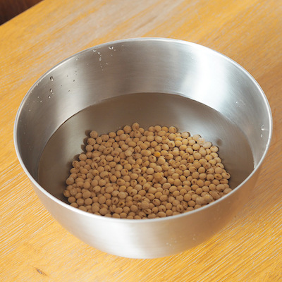 大豆を濁りがなくなるまでよく洗います。大豆は水を吸うと数倍の大きさになるためたっぷりの水に一晩つけておきます。皮がピンと張るくらいが目安です。
