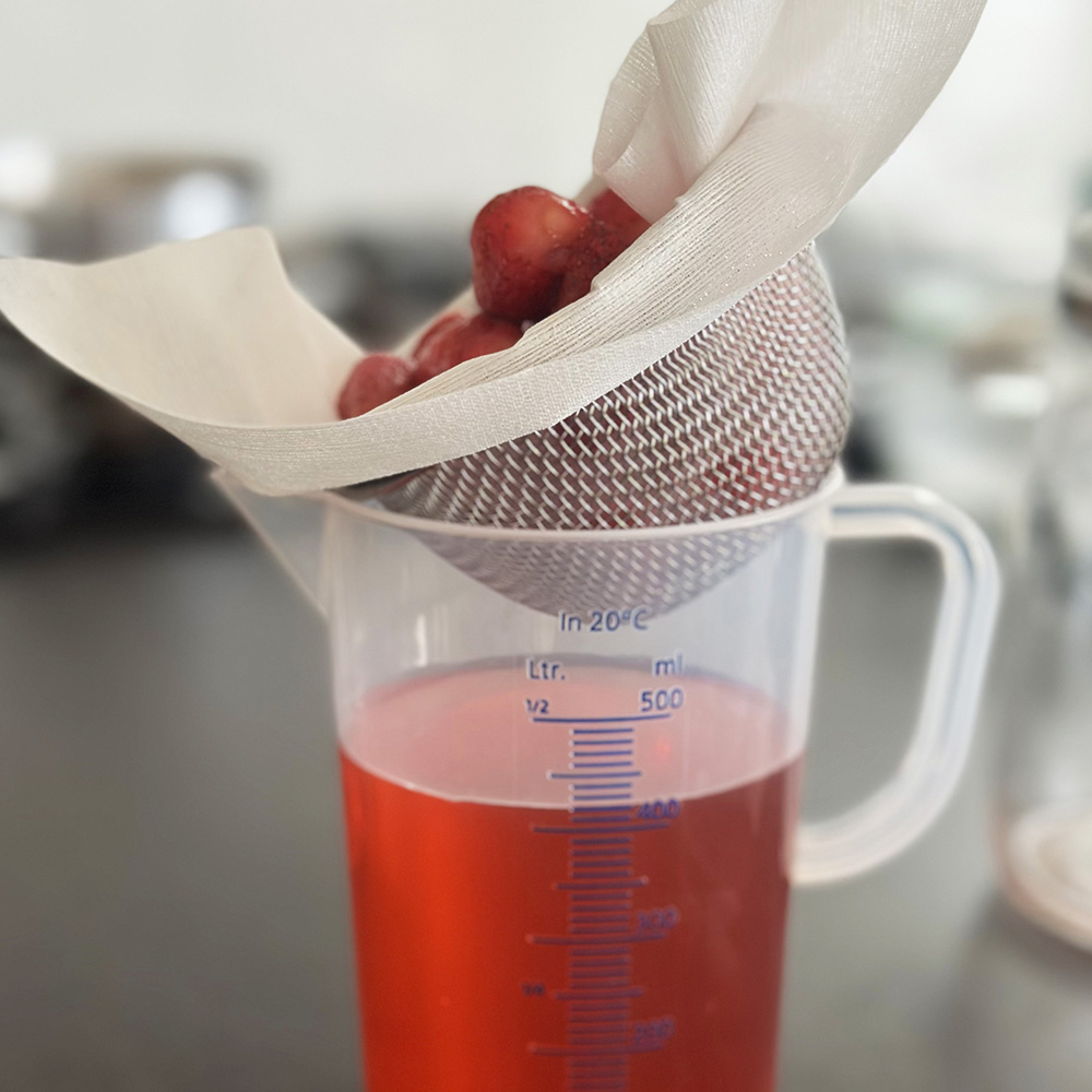 シロップを漉します。苺は潰さずに時間をかけて漉します。苺のヒゲなどを取り除くとドリンクにした時に綺麗なので「ひと手間」かけましょう。