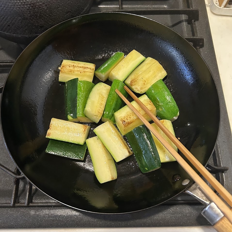 次に、フライパンにごま油大さじ1を入れて中火で熱します。油が温まったら、ズッキーニを入れて炒めます。