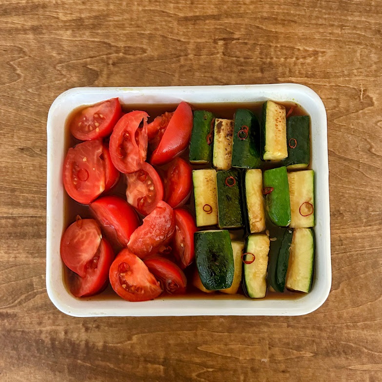 ズッキーニにこんがりと焼き色がついたら火を止め、先に準備しておいた2で作った調味液とトマトの入った容器に加え軽く混ぜ合わせてください。粗熱をとり、冷蔵庫で冷やします。冷蔵で3〜4日ほど保存可能です。